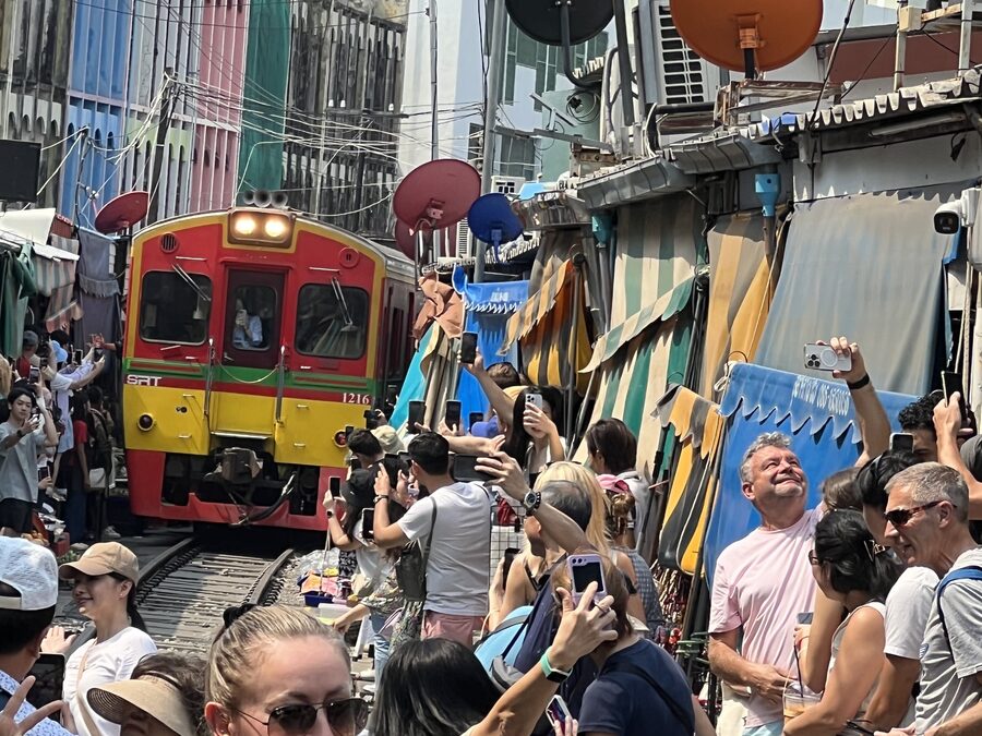 A train passing through the stalls at Maeklong railway market